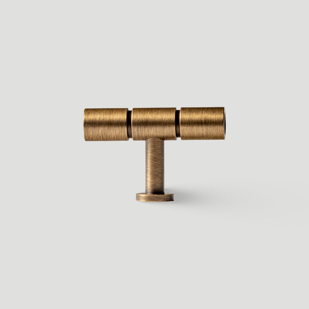 Vintage bronze brass T-bar cabinet pull, shown from one angle on a clean neutral background