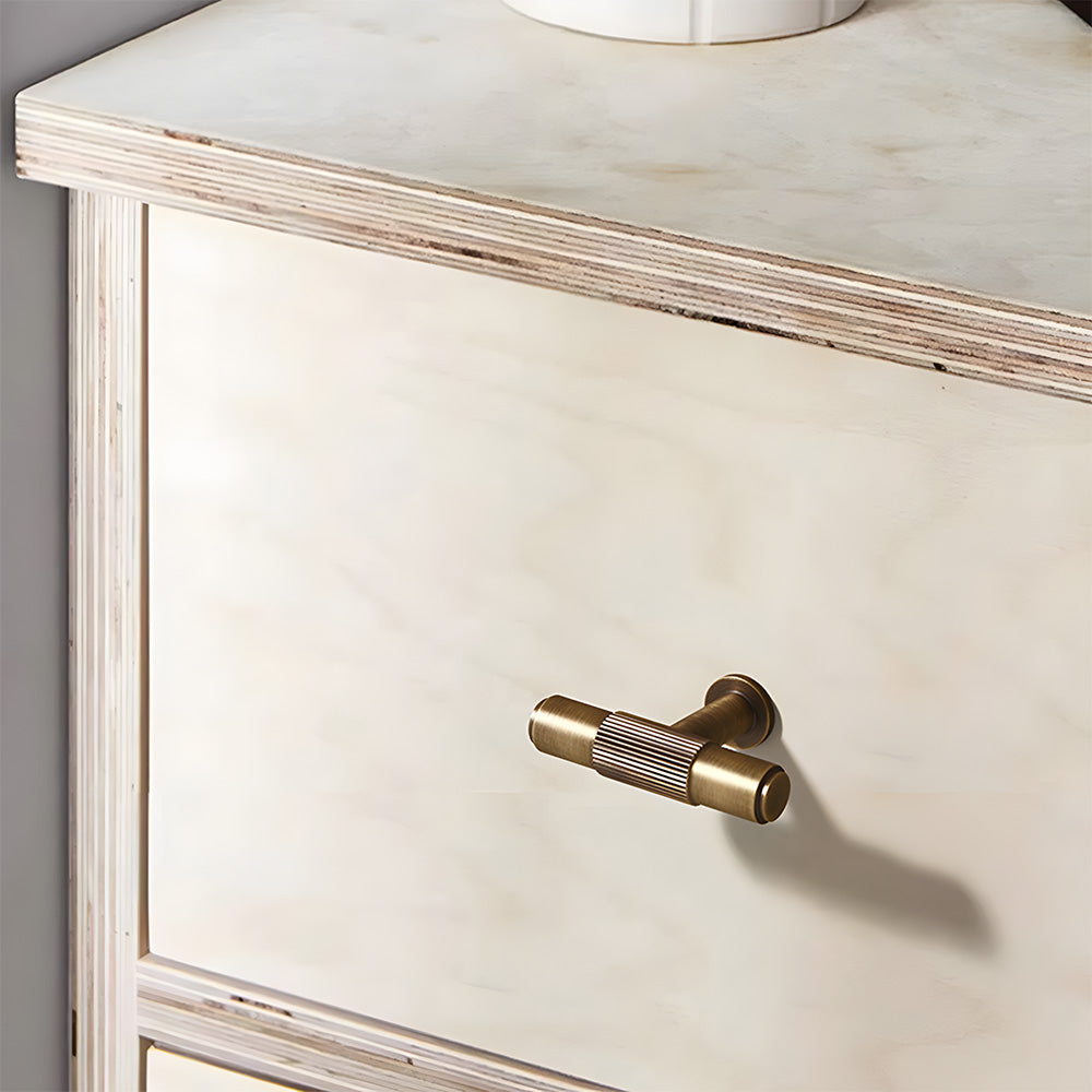 Lined aged-bronze brass T-bar cabinet pull and knob, shown at close range in an installed cabinet close-up