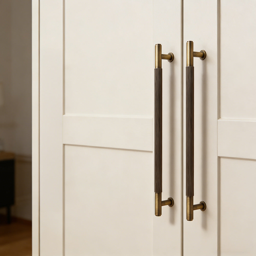 Lined aged-bronze brass T-bar cabinet pull and knob, shown from one angle with the finish and grip area visible