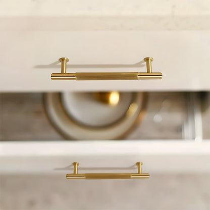 Lined aged-bronze brass T-bar cabinet pull and knob, shown from one angle installed on cabinetry in context