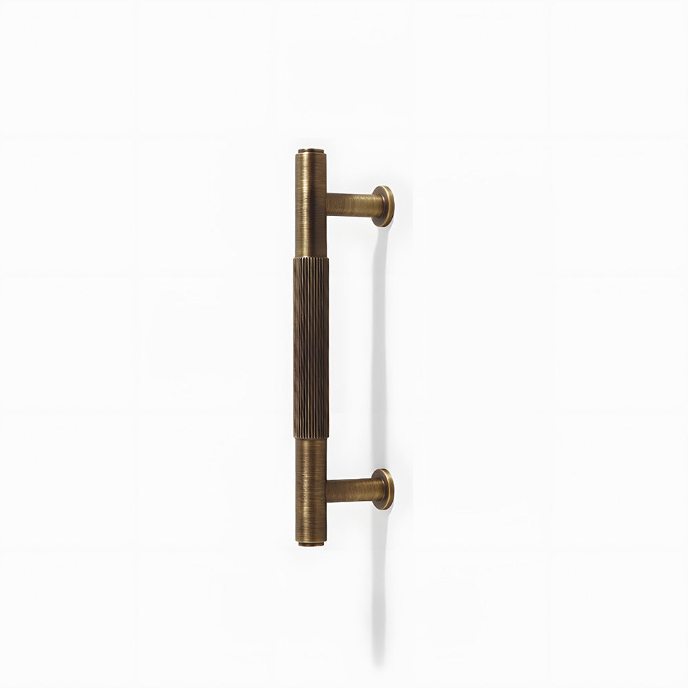 Lined aged-bronze brass T-bar cabinet pull and knob, shown from one angle on a clean neutral background