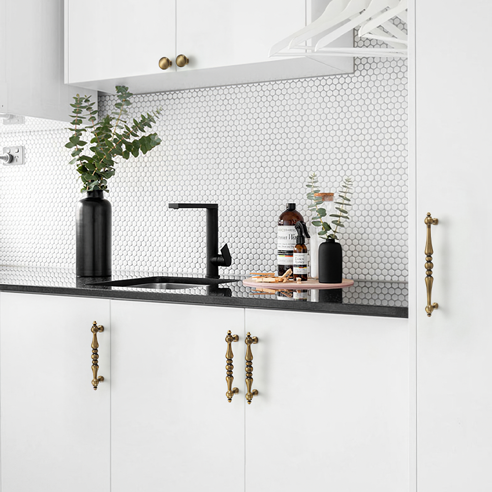 Bronze vintage turned brass cabinet pull and round knob, shown at close range installed on cabinetry in context