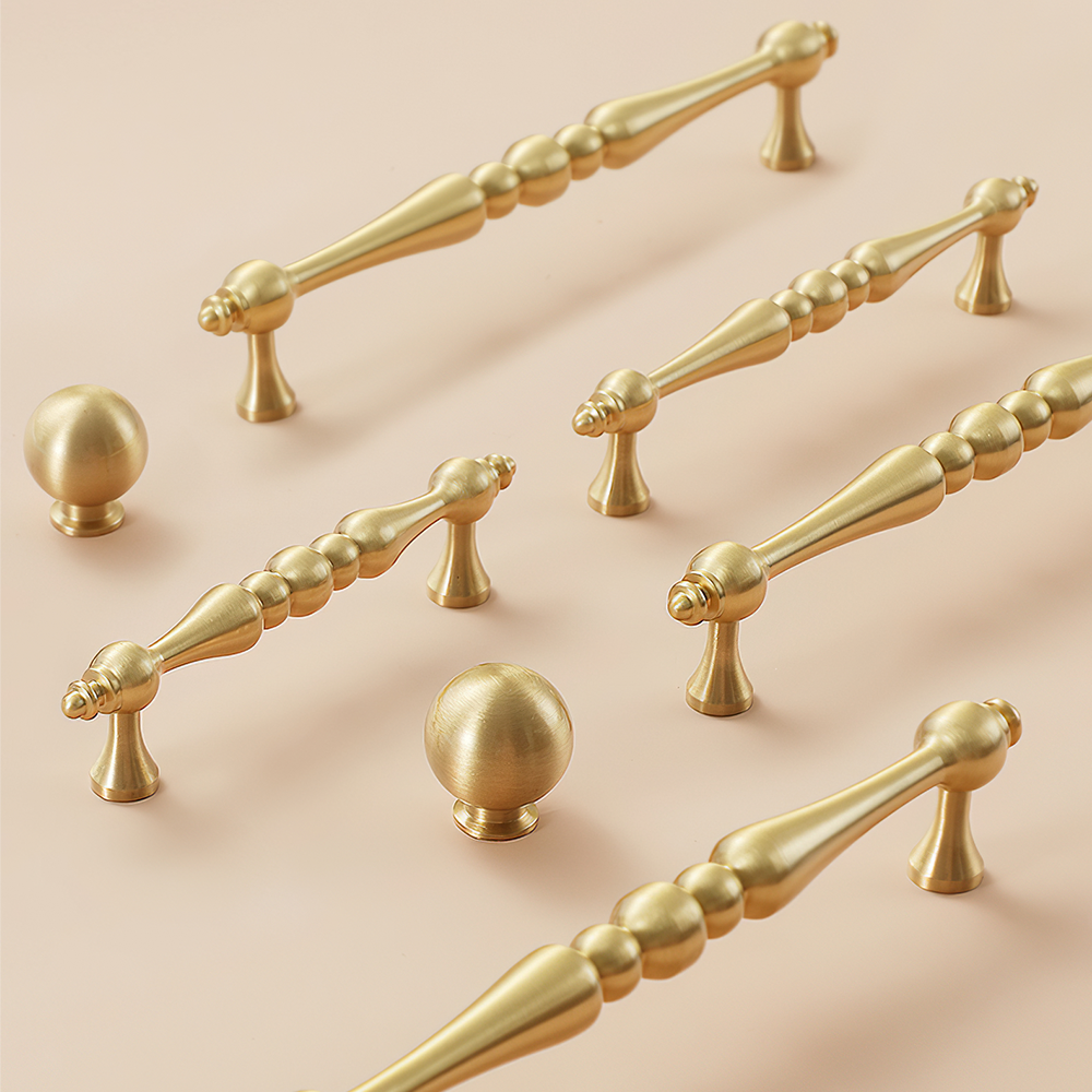 Gold vintage turned brass cabinet pull and round knob, shown from one angle as a color and finish lineup