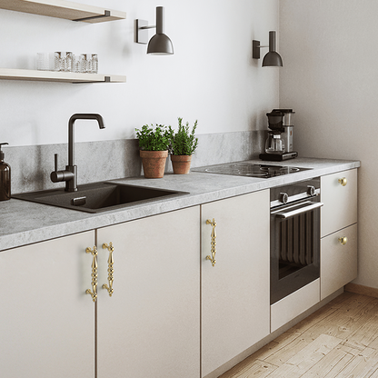 Vintage turned brass cabinet pull and round knob, shown clearly installed on cabinetry in context