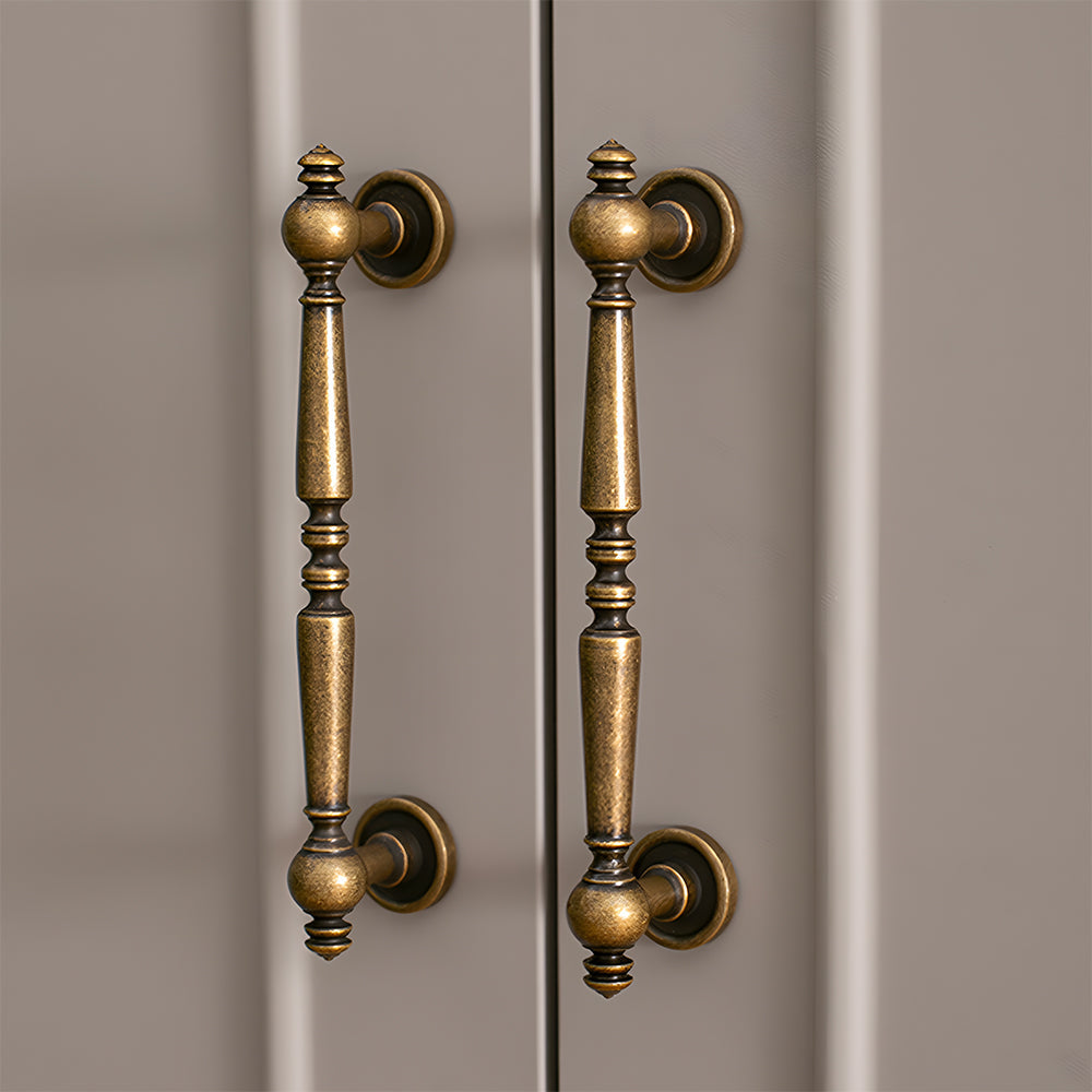 Bronze vintage turned brass cabinet pull and round knob, shown from one angle installed on cabinetry in context