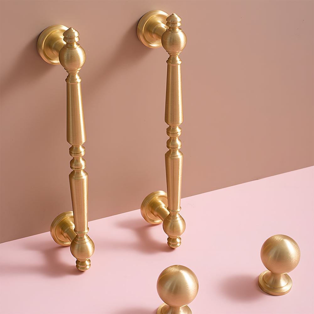 Vintage turned brass cabinet pull and round knob, displayed from the side installed on cabinetry in context