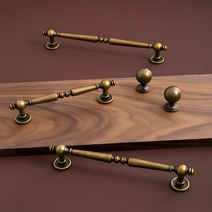 Vintage turned brass cabinet pull and round knob, shown from one angle as a color and finish lineup
