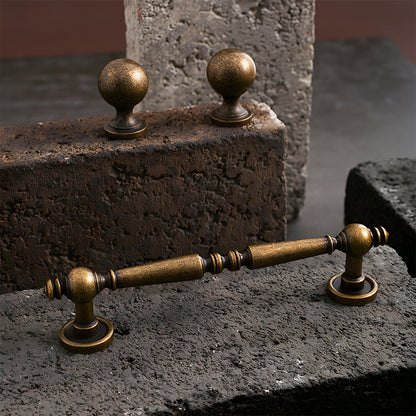 Vintage turned brass cabinet pull and round knob, shown at close range as a color and finish lineup