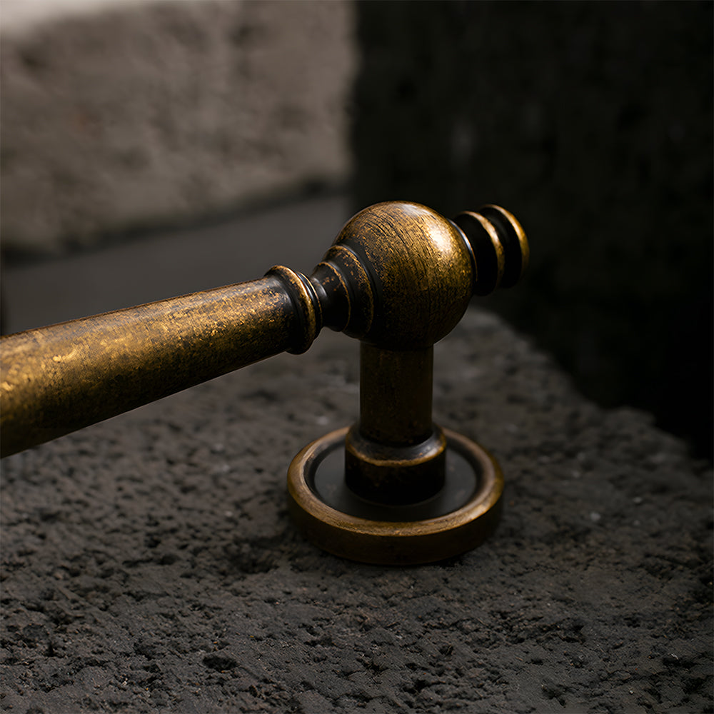 Vintage turned brass cabinet pull and round knob, shown clearly in an installed cabinet close-up