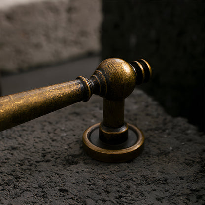 Vintage turned brass cabinet pull and round knob, shown clearly in an installed cabinet close-up