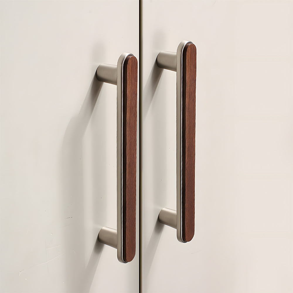 Walnut inlay cabinet pull in silver with 128 mm centers, installed on paired cabinet doors in a close view