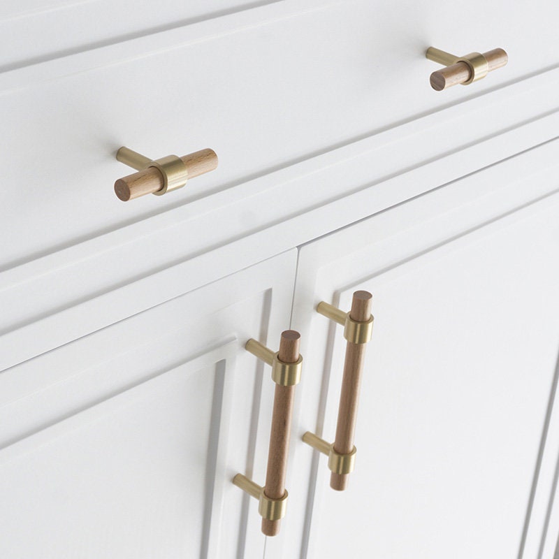 Wood cabinet pull with brass bases in beech with 224 mm centers, shown in a close installed view across cabinet fronts