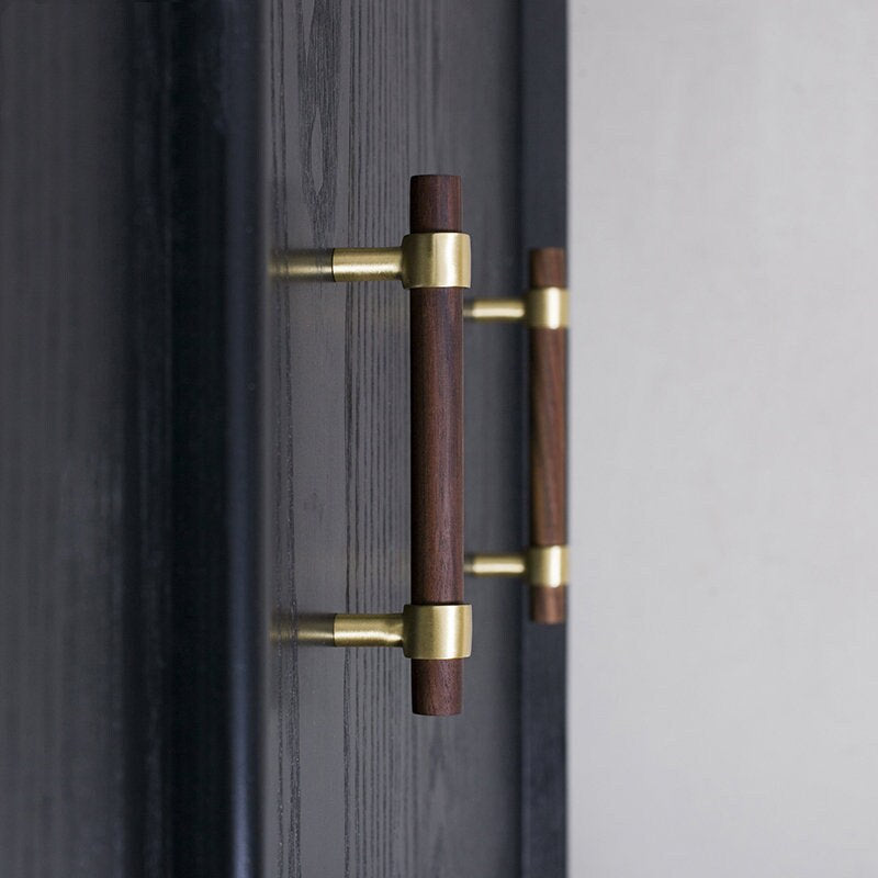 Wood cabinet pull with brass bases, mounted on tall cabinet doors in a wider room view