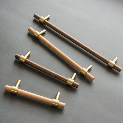 Walnut or beech wood cabinet pull with brushed brass bases, grouped on a light surface to compare lengths and profiles