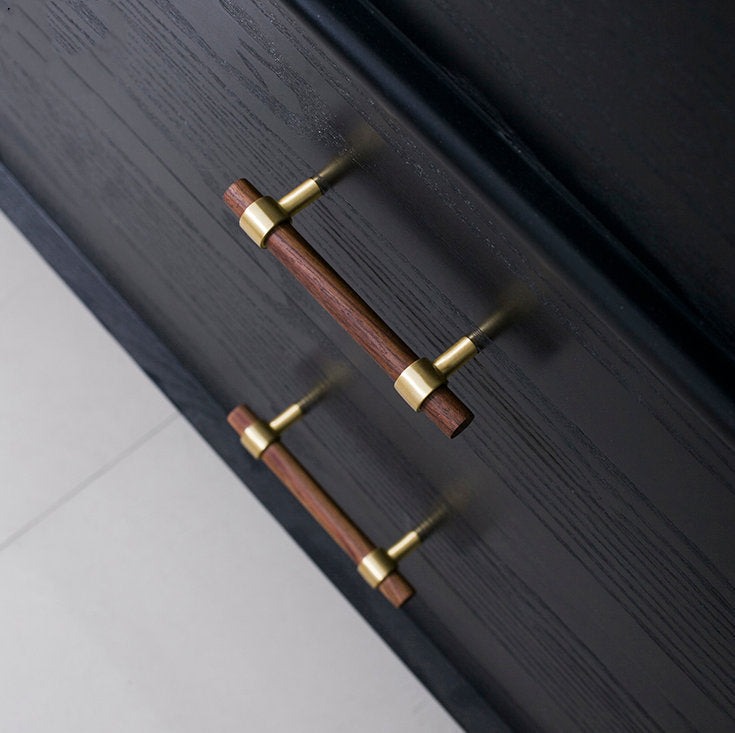 Wood cabinet pull with brass bases in black walnut with 128 mm centers, shown on cabinet fronts in a bright room setting