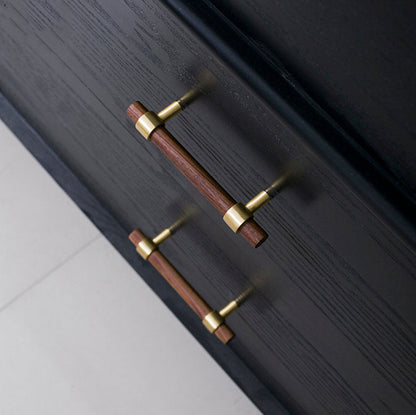 Wood cabinet pull with brass bases in black walnut with 128 mm centers, shown on cabinet fronts in a bright room setting
