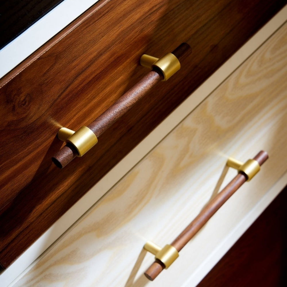 Walnut or beech wood cabinet pull with brushed brass bases, shown across several drawer fronts in a cabinet scene