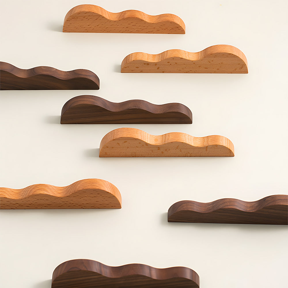 Wavy wood cabinet pull with a sculpted three-curve profile, grouped on a light surface to compare lengths and profiles