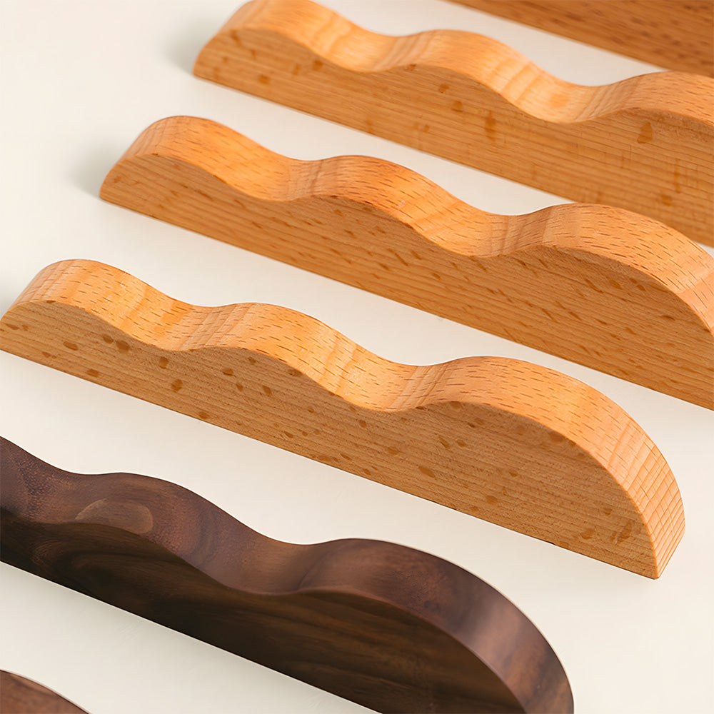 Wavy wood cabinet pull with a sculpted three-curve profile, shown in a styled group with multiple available versions