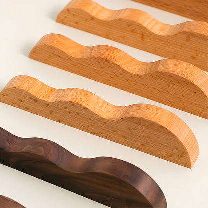 Wavy wood cabinet pull with a sculpted three-curve profile, shown in a styled group with multiple available versions