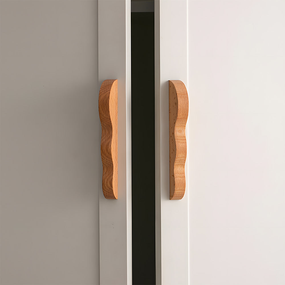 Wavy wood cabinet pull in natural wood with 96 mm centers, shown on cabinet fronts in a bright room setting
