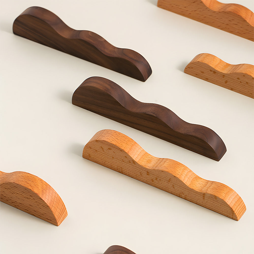 Wavy wood cabinet pull with a sculpted three-curve profile, arranged together for a size and style comparison