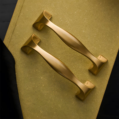 Wide arched brass cabinet pull with flared square ends, shown at close range as a color and finish lineup
