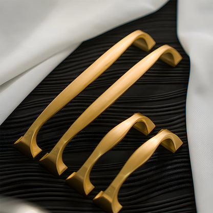 Wide arched brass cabinet pull with flared square ends, presented for reference as a color and finish lineup