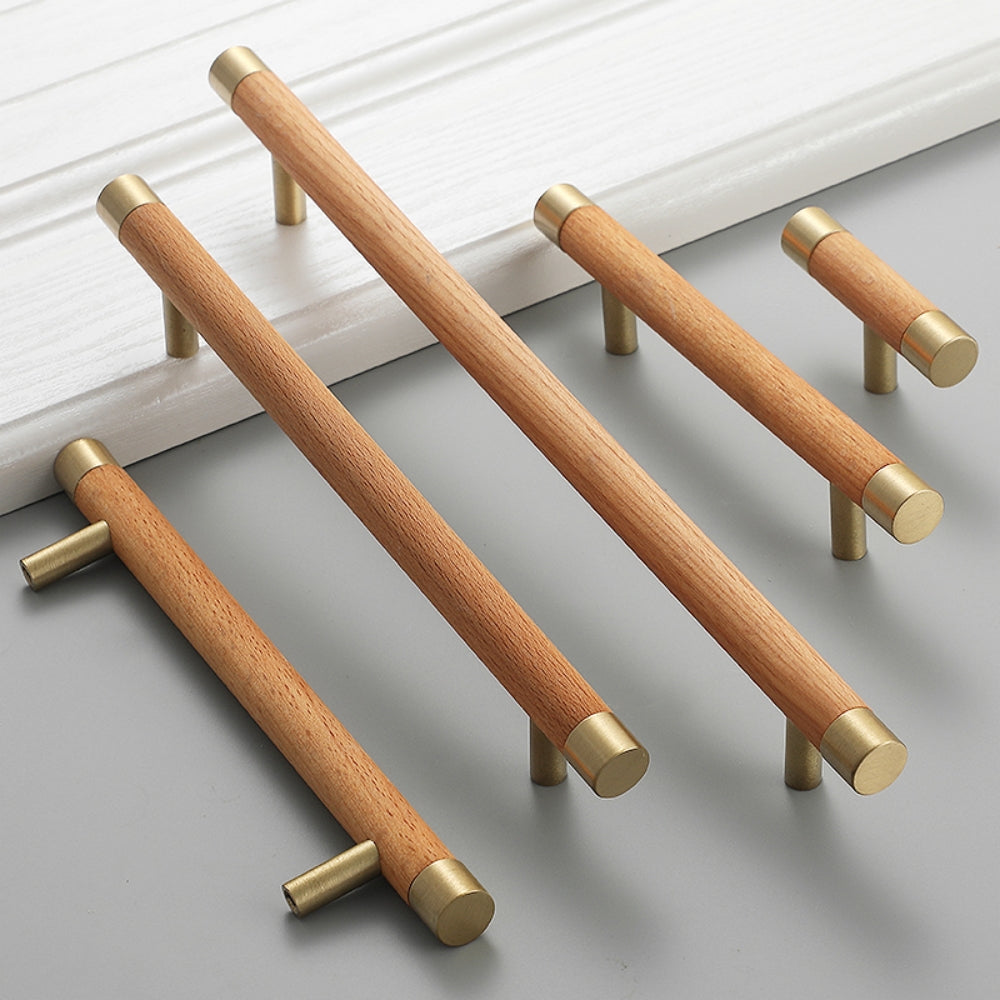 Light wood cabinet handle with brushed brass end caps, grouped in long and short versions on a neutral surface