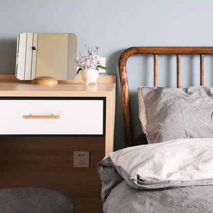 Light wood cabinet handle with brushed brass end caps, shown across a complete storage cabinet in a room setting