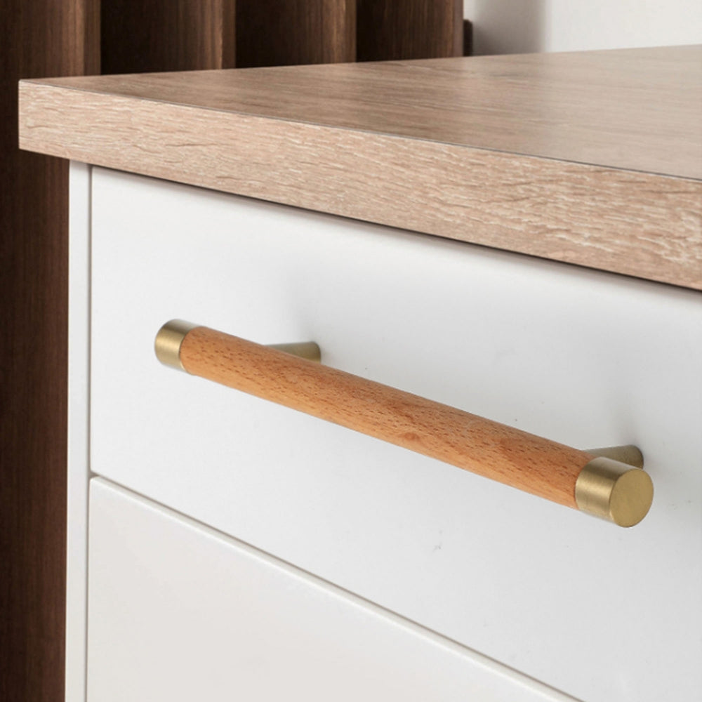 Light wood cabinet handle with brushed brass end caps, shown across several drawer fronts in a cabinet scene