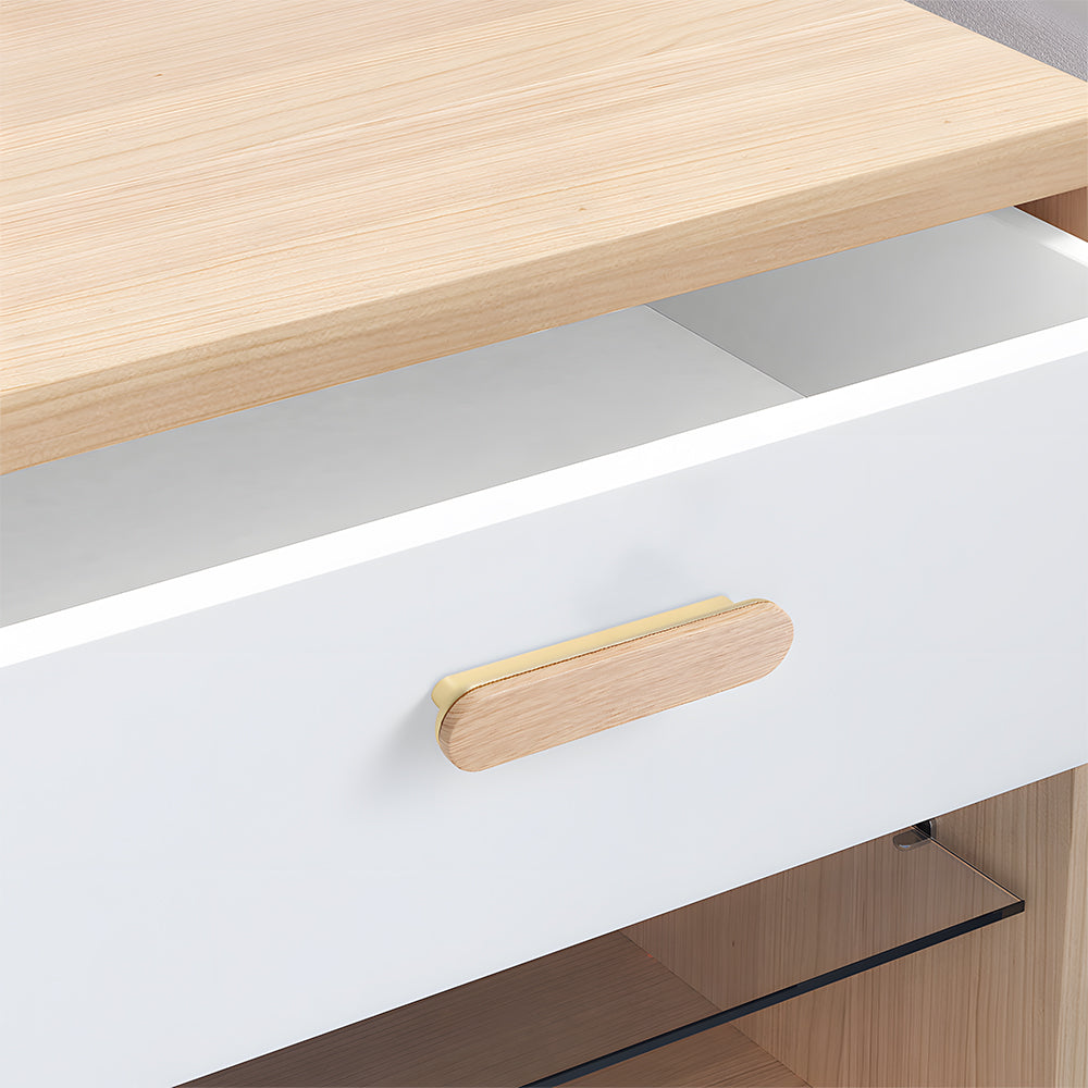 Wood-grain cabinet pull in light wood with a gold base with 96 mm centers, installed horizontally on a drawer front