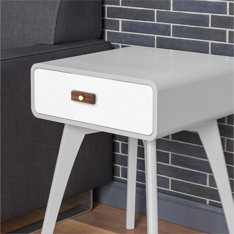 Wood-grain cabinet pull with round black or gold metal posts, installed horizontally on a drawer front in a close view