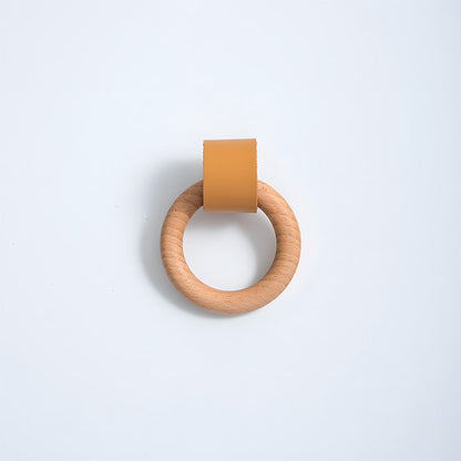 Wood ring cabinet knob with a caramel leather strap in a straight-on view on a white background