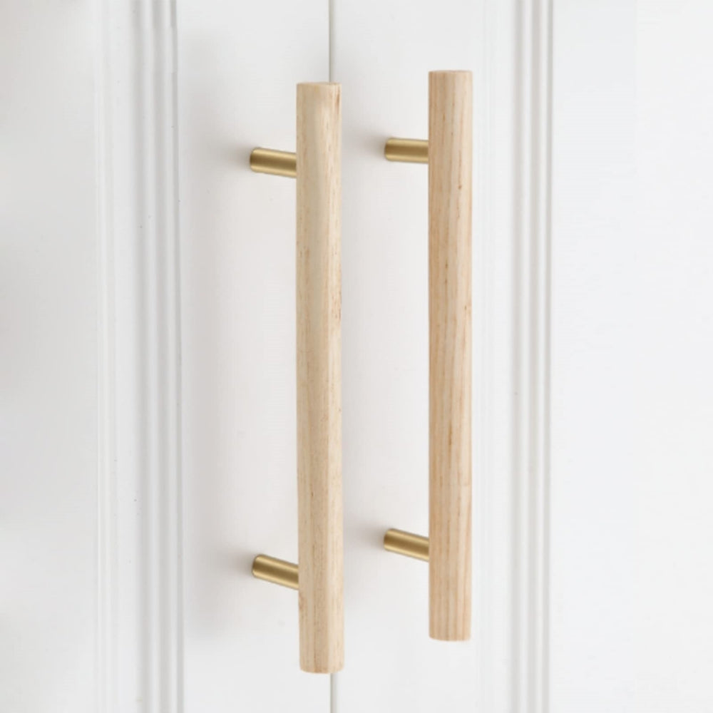 Wood cabinet pull with brass posts in ash wood with 160 mm centers, installed on cabinet doors in a close furniture view