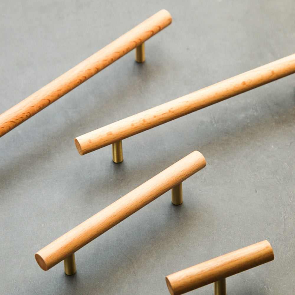 Wood cabinet pull with brass posts in light wood, arranged together from an overhead angle for comparison