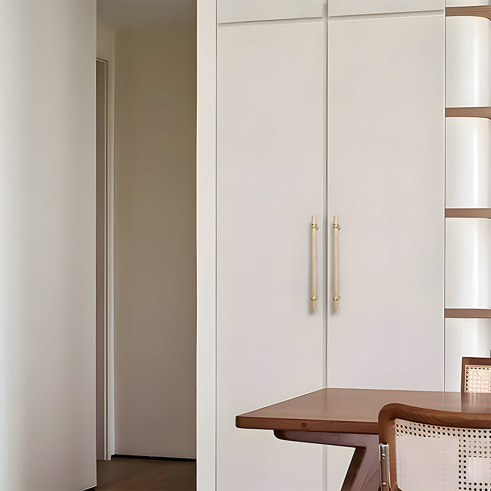 Wood and brass round bar cabinet pull with collar details, installed vertically on paired wardrobe doors