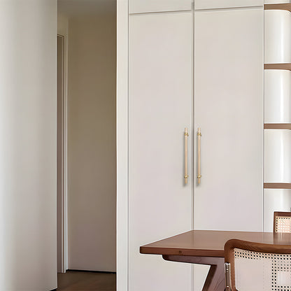 Wood and brass round bar cabinet pull with collar details, installed vertically on paired wardrobe doors