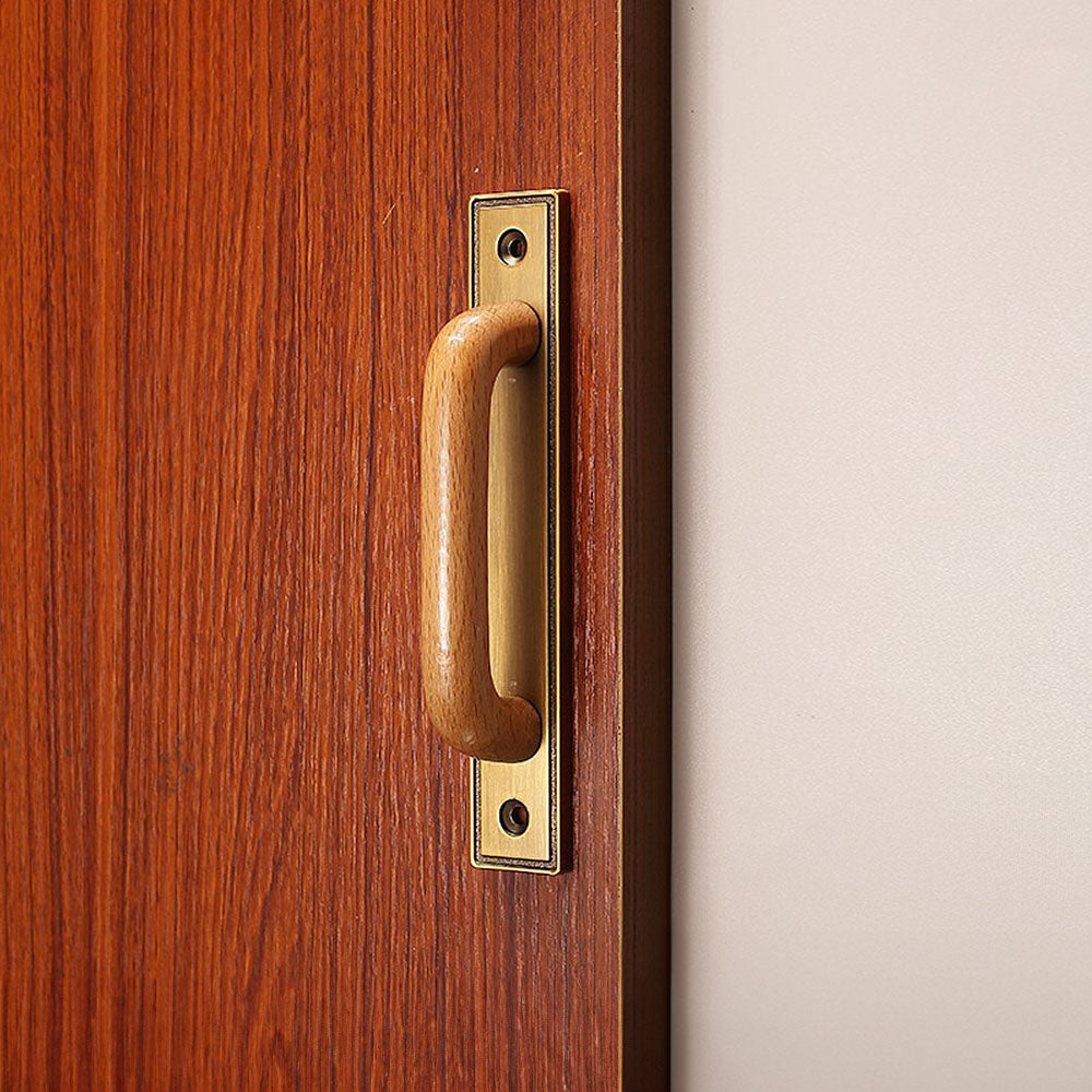 Wood cabinet pull with a rectangular metal backplate, shown clearly installed on cabinetry in context