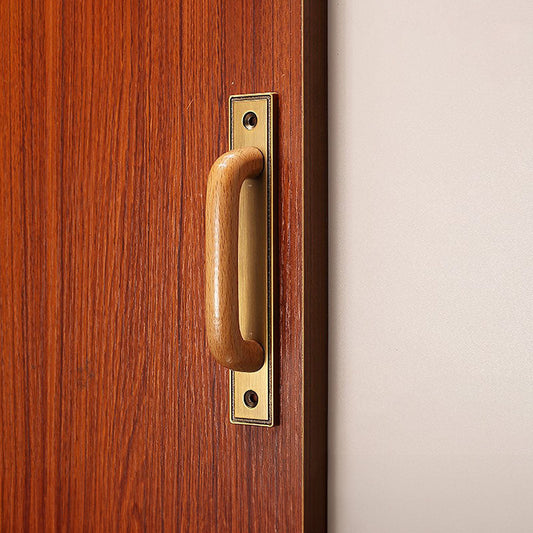 Wood cabinet pull with a rectangular metal backplate, shown clearly installed on cabinetry in context