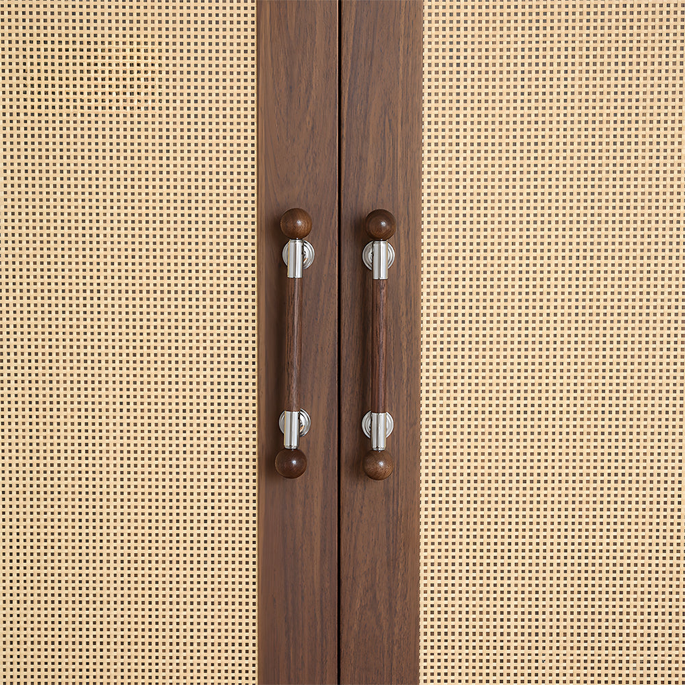 Round wood bar cabinet pull with brass mounts, installed on cabinet doors with a hand reaching toward it