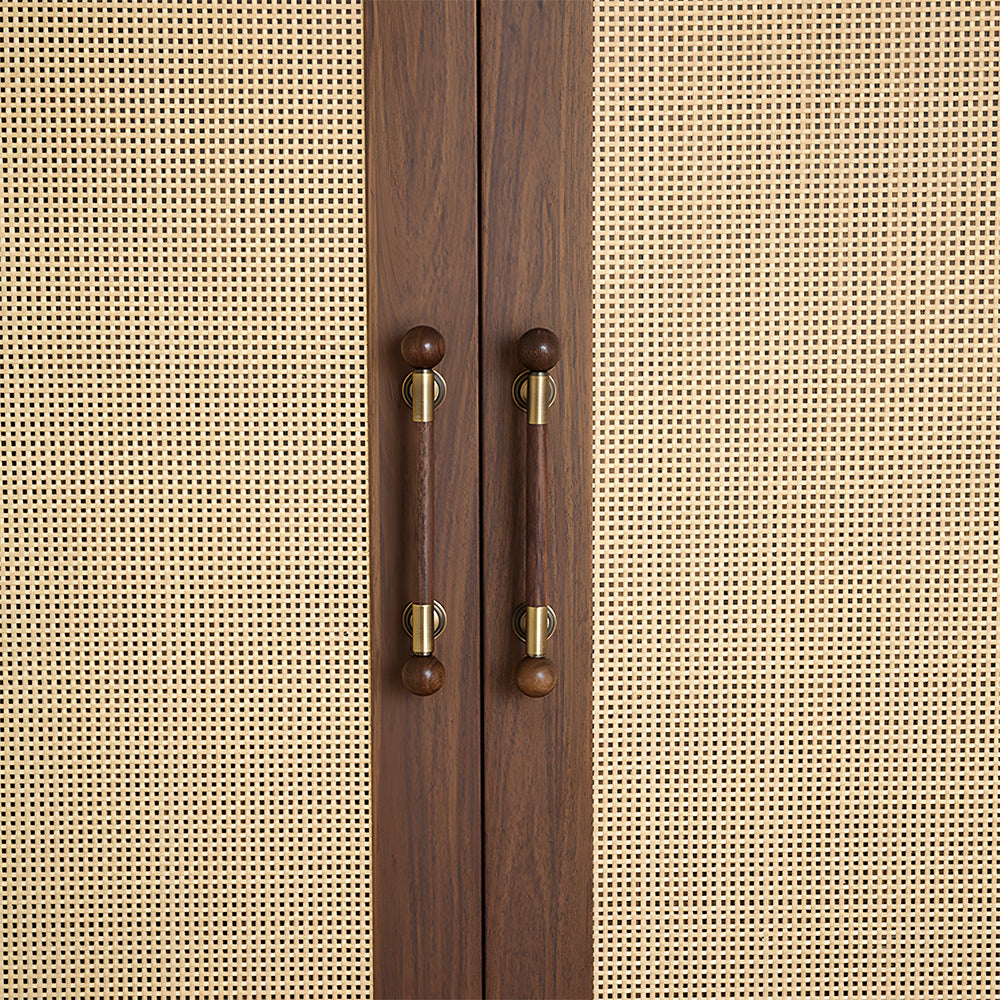 Round wood bar cabinet pull with brass mounts, installed on paired cabinet doors in a close view