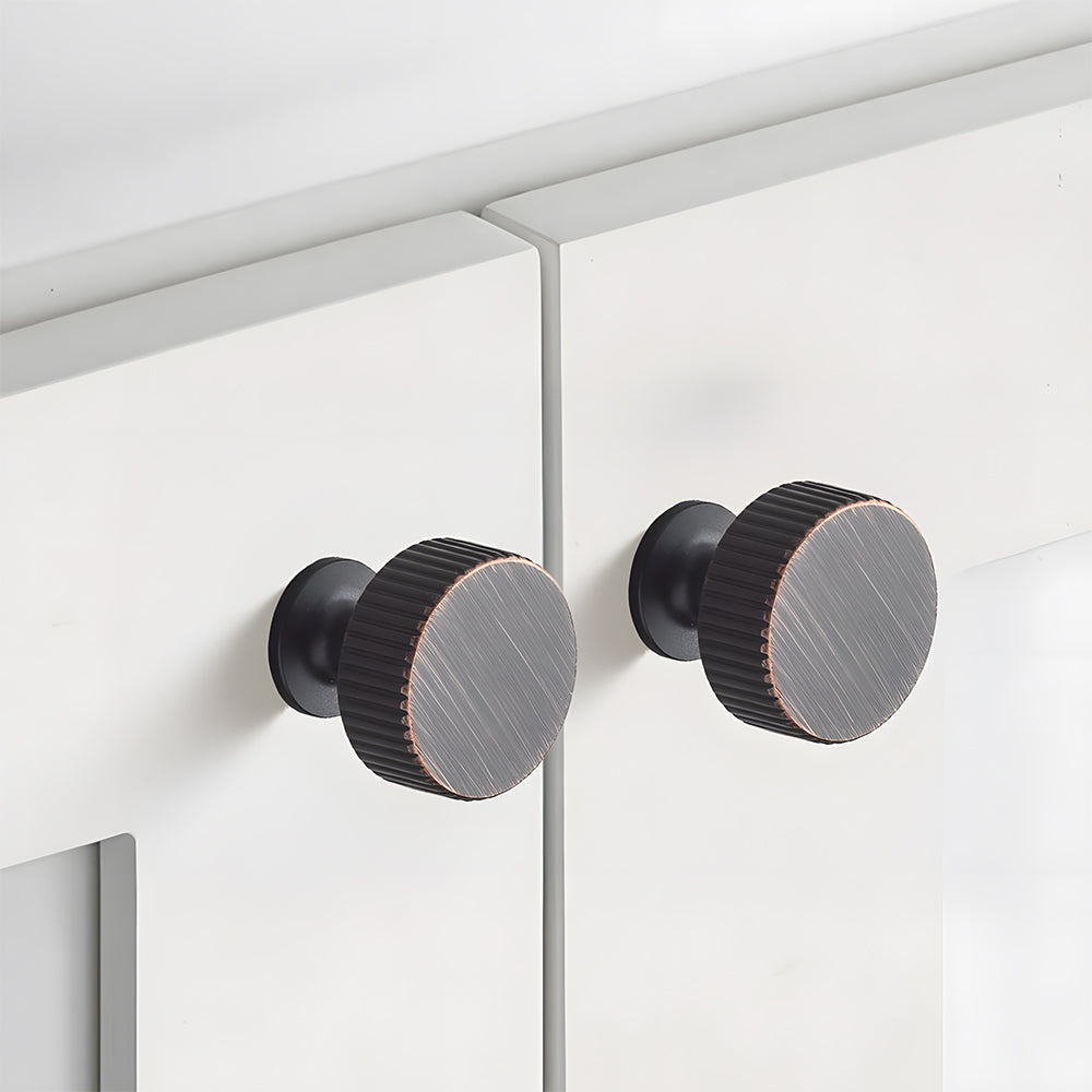 Bronze red fluted bar cabinet pull and round knob, shown at close range in an installed cabinet close-up